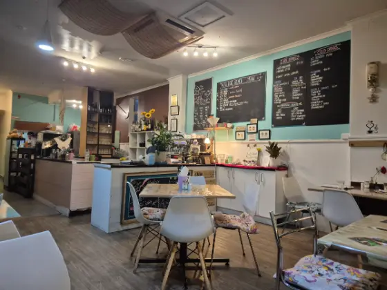 Inside Faith Hope Love: seafoam walls, chalkboard menus over the counter and white chairs at timber tables